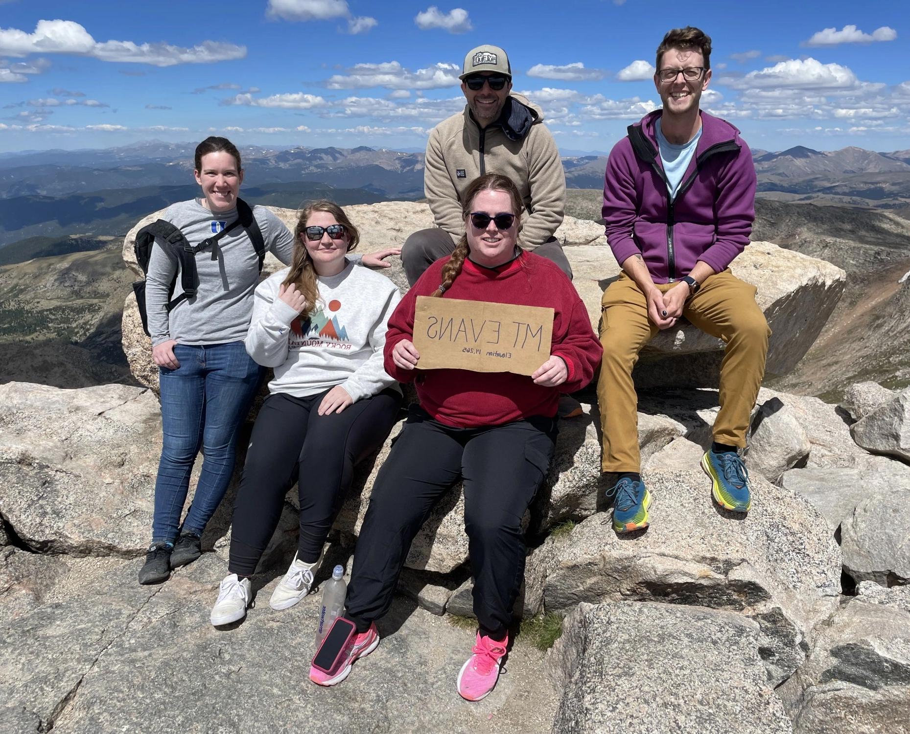 乔恩·维洛塔(Jon Velotta)和他的学生研究人员坐在蓝天山(以前被称为山)的山顶上. Evans.